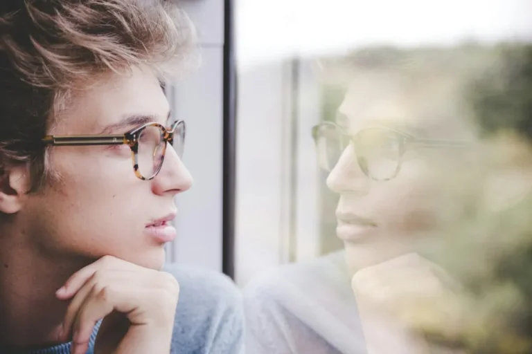 A thoughtful person looking out a window