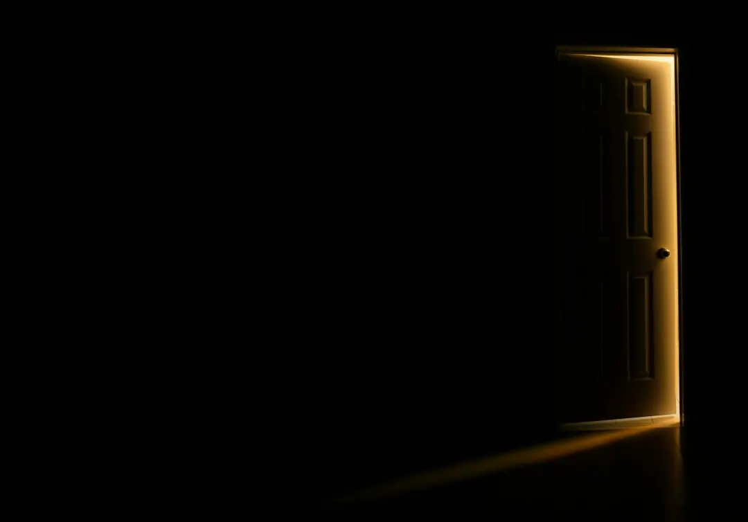 A door slightly open with light coming through